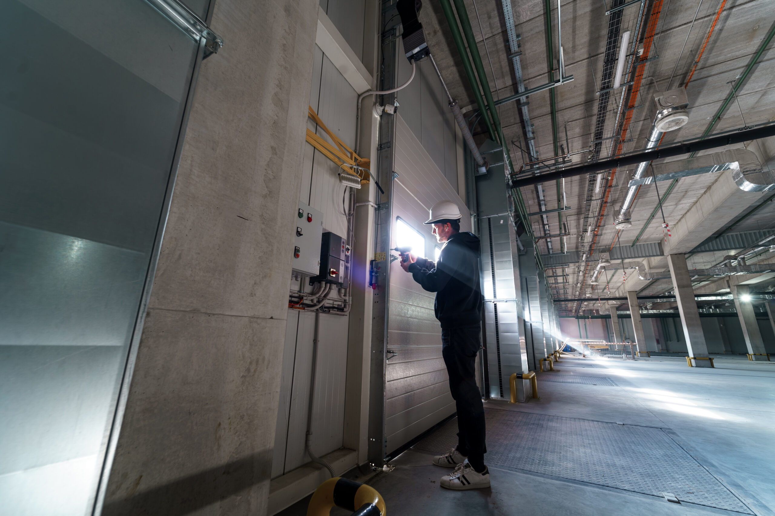 Engineer repairing an unloading gate at a large commercial warehouse